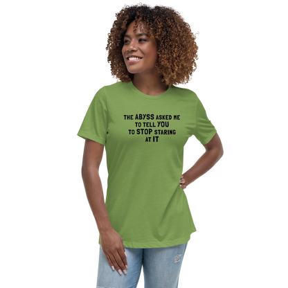 "The Abyss asked me to tell you to stop staring at it" printed on a leaf women's relaxed t-shirt worn by a female