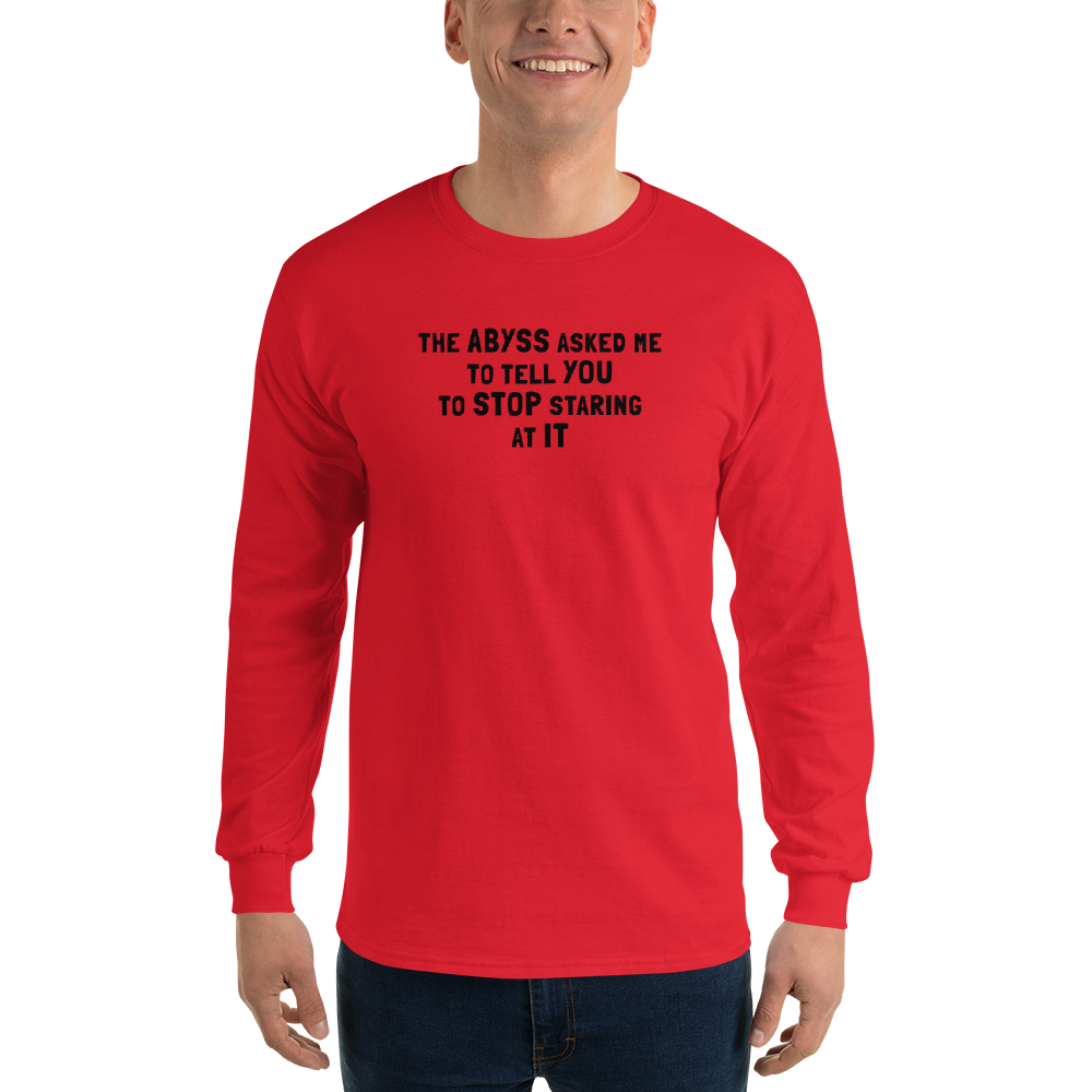 "The Abyss asked me to tell you to stop staring at it" printed on a red men's long sleeve shirt worn by a male