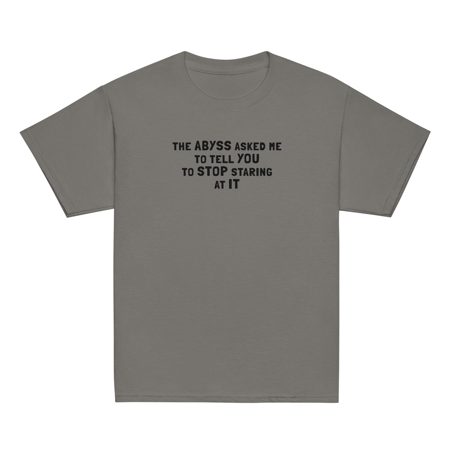 "The Abyss asked me to tell you to stop staring at it" printed on a charcoal youth classic tee laying on a flat surface