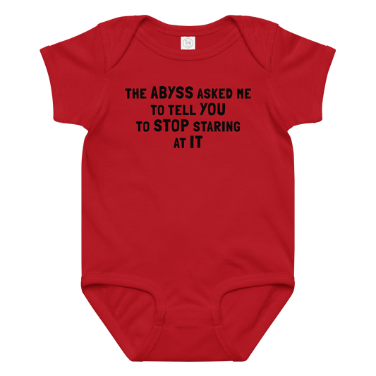 "The Abyss asked me to tell you to stop staring at it" printed on a red baby jersey bodysuit laying on a flat surface amongst other clothes