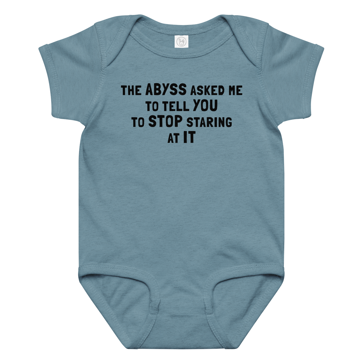 "The Abyss asked me to tell you to stop staring at it" printed on a vintage indigo baby jersey bodysuit laying on a flat surface amongst other clothes