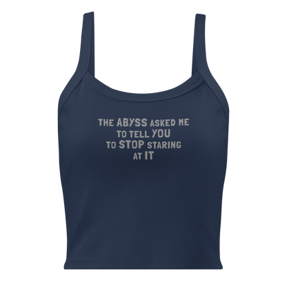 "The Abyss asked me to tell you to stop staring at it" printed on a solid navy blend women's micro-rib tanktop laying on a flat surface