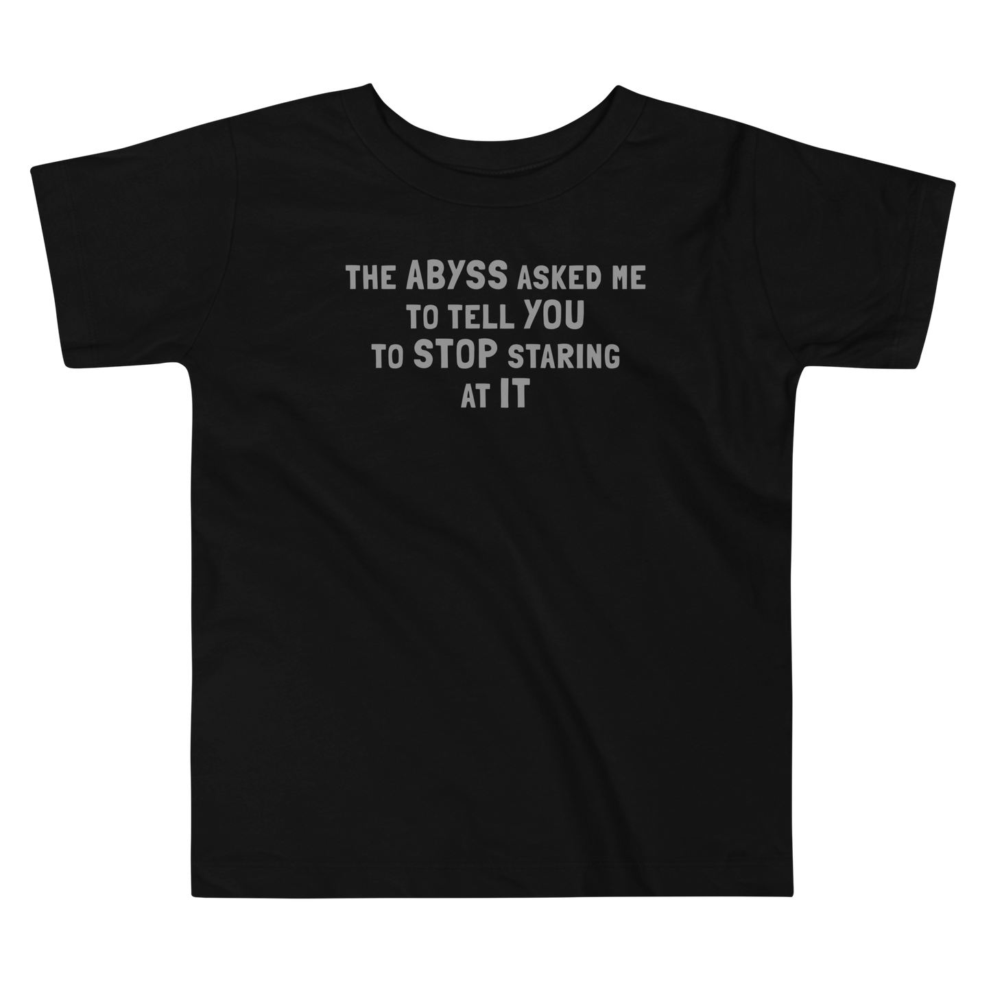 "The Abyss asked me to tell you to stop staring at it" printed on a black toddler short sleeve tee laying on a flat surface