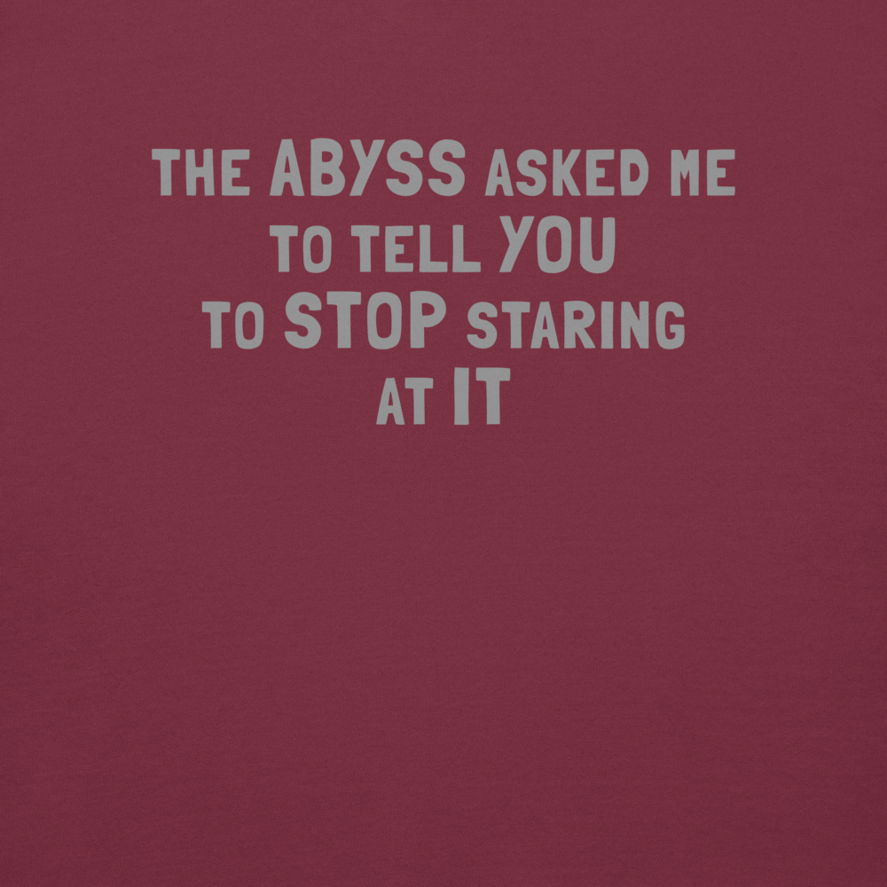 "The Abyss asked me to tell you to stop staring at it" printed on a maroon background