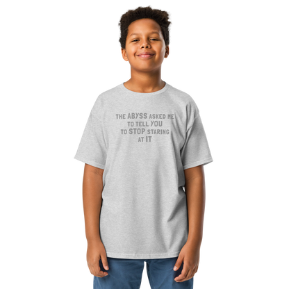"The Abyss asked me to tell you to stop staring at it" printed on a sport grey youth classic tee worn by a male