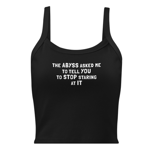 "The Abyss asked me to tell you to stop staring at it" printed on a solid black blend women's micro-rib tanktop laying on a flat surface
