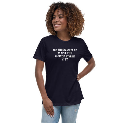 "The Abyss asked me to tell you to stop staring at it" printed on a navy women's relaxed t-shirt worn by a female