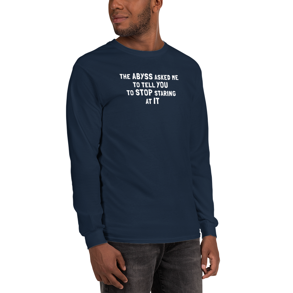 "The Abyss asked me to tell you to stop staring at it" printed on a navy men's long sleeve shirt worn by a male