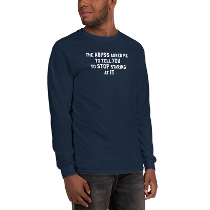 "The Abyss asked me to tell you to stop staring at it" printed on a navy men's long sleeve shirt worn by a male