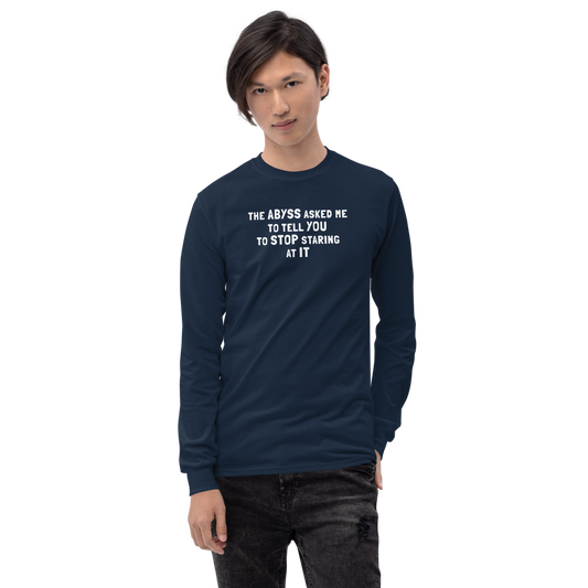 "The Abyss asked me to tell you to stop staring at it" printed on a navy men's long sleeve shirt worn by a male