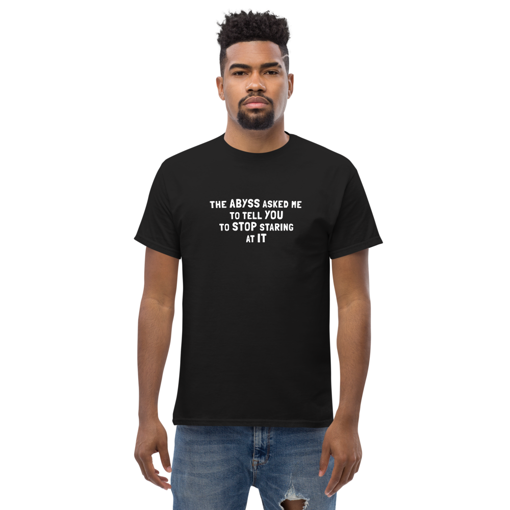 "The Abyss asked me to tell you to stop staring at it" printed on a black unisex classic tee worn by a male