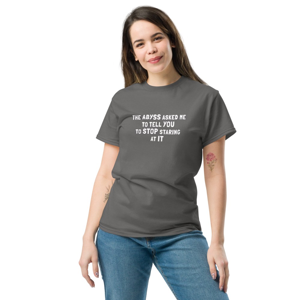 "The Abyss asked me to tell you to stop staring at it" printed on a charcoal unisex classic tee worn by a female