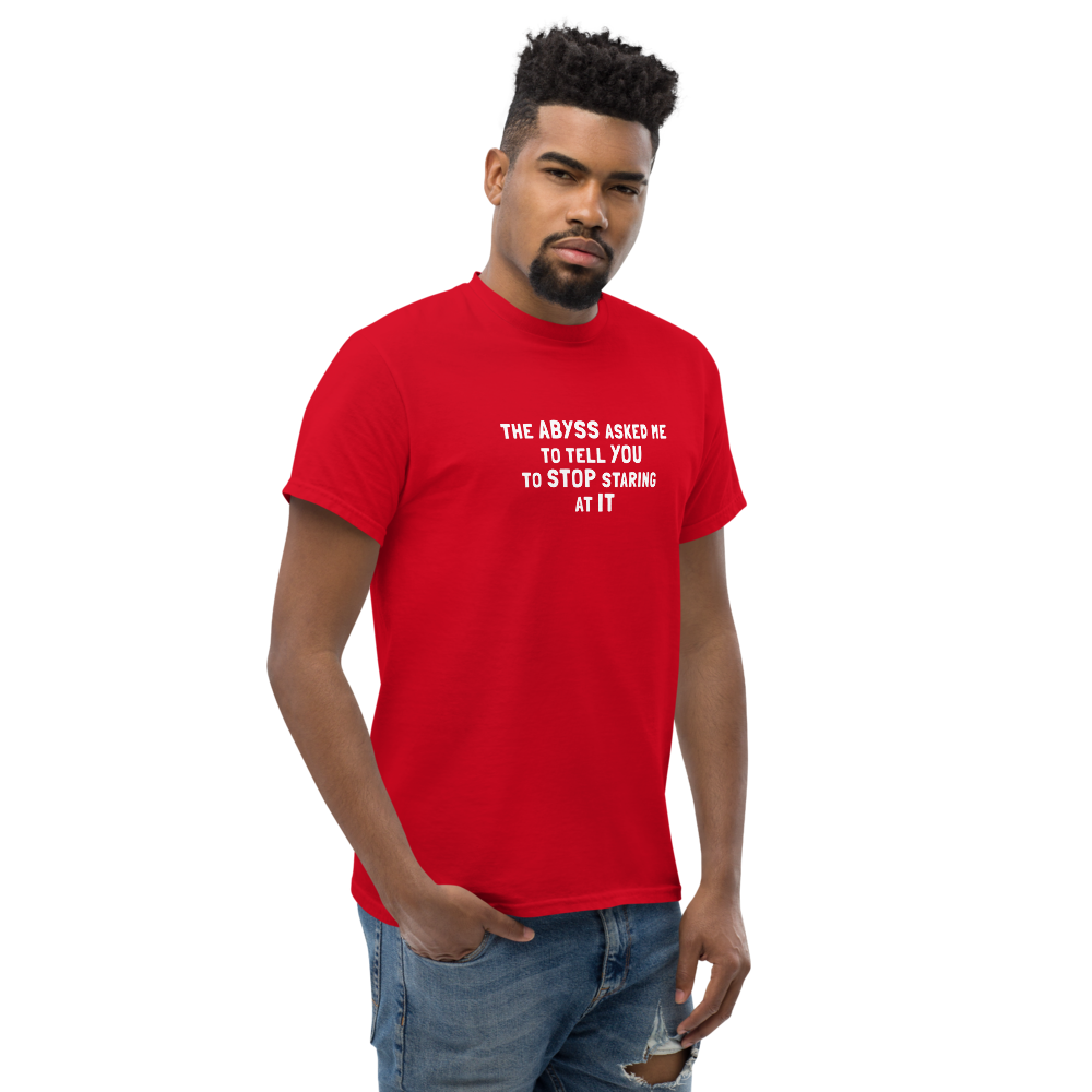 "The Abyss asked me to tell you to stop staring at it" printed on a red unisex classic tee worn by a male