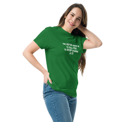 "The Abyss asked me to tell you to stop staring at it" printed on a turf green unisex classic tee worn by a female