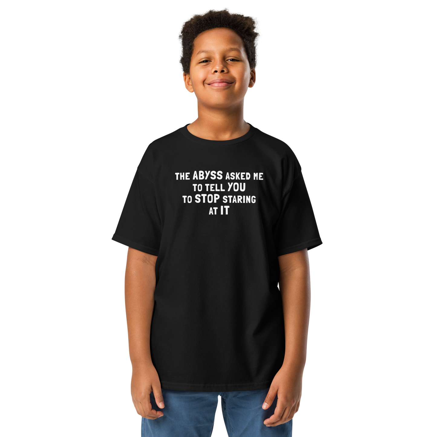 "The Abyss asked me to tell you to stop staring at it" printed on a black youth classic tee worn by a male