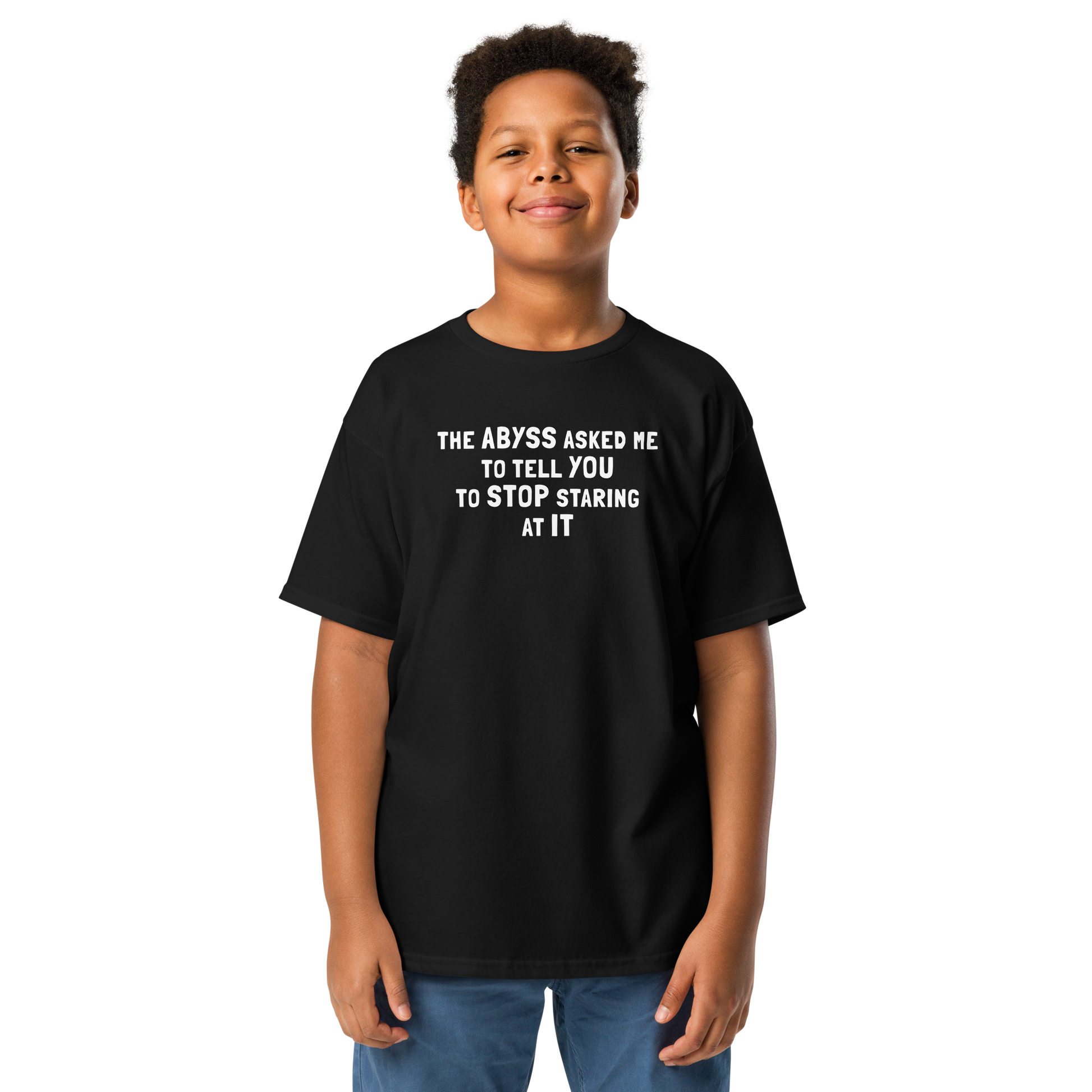"The Abyss asked me to tell you to stop staring at it" printed on a black youth classic tee worn by a male
