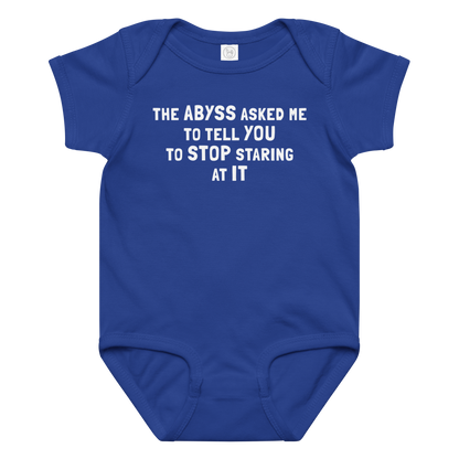 "The Abyss asked me to tell you to stop staring at it" printed on a royal baby jersey bodysuit laying on a flat surface amongst other clothes