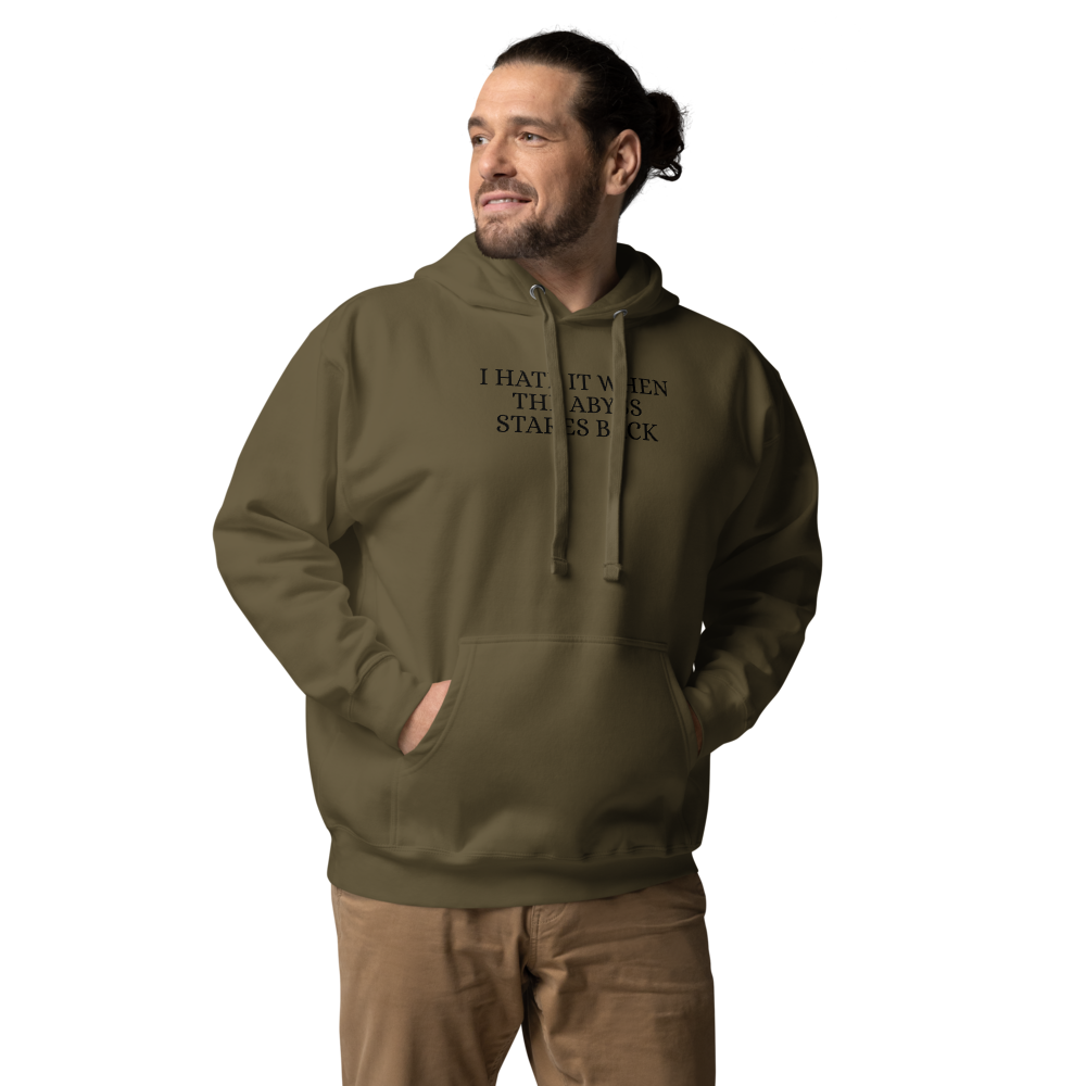 "I hate it when the abyss stares back" printed on a military green unisex hoodie worn by a male