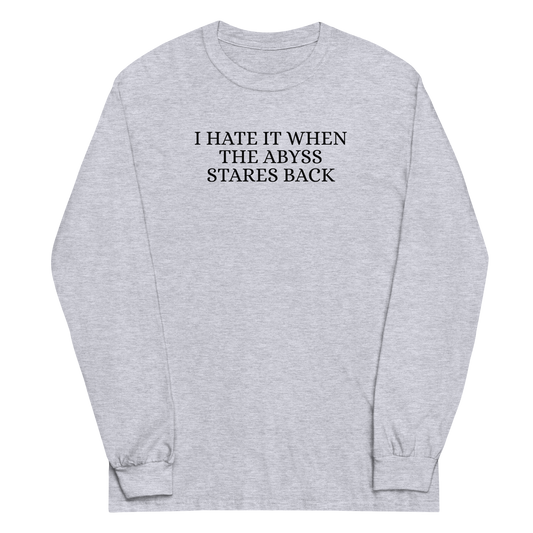 "I hate it when the abyss stares back" printed on a sport grey men's long sleeve shirt laying on a flat surface