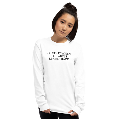 "I hate it when the abyss stares back" printed on a white men's long sleeve shirt worn by a female