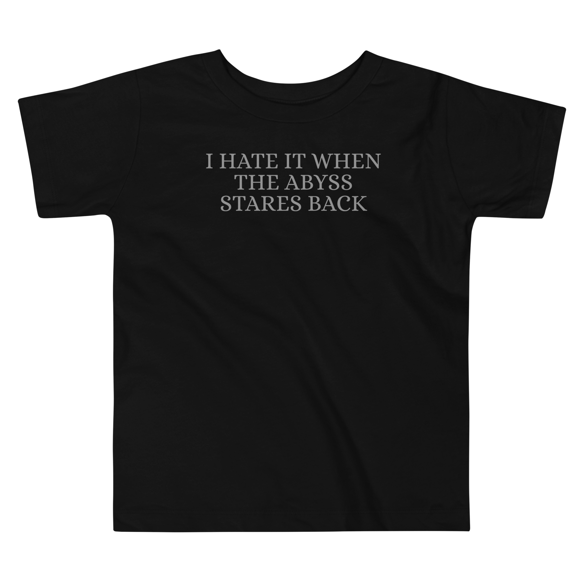 "I hate it when the abyss stares back" printed on a black toddler short sleeve tee laying on a flat surface
