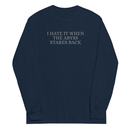 "I hate it when the abyss stares back" printed on a navy men's long sleeve shirt laying on a flat surface