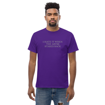 "I hate it when the abyss stares back" printed on a purple unisex classic tee worn by a male
