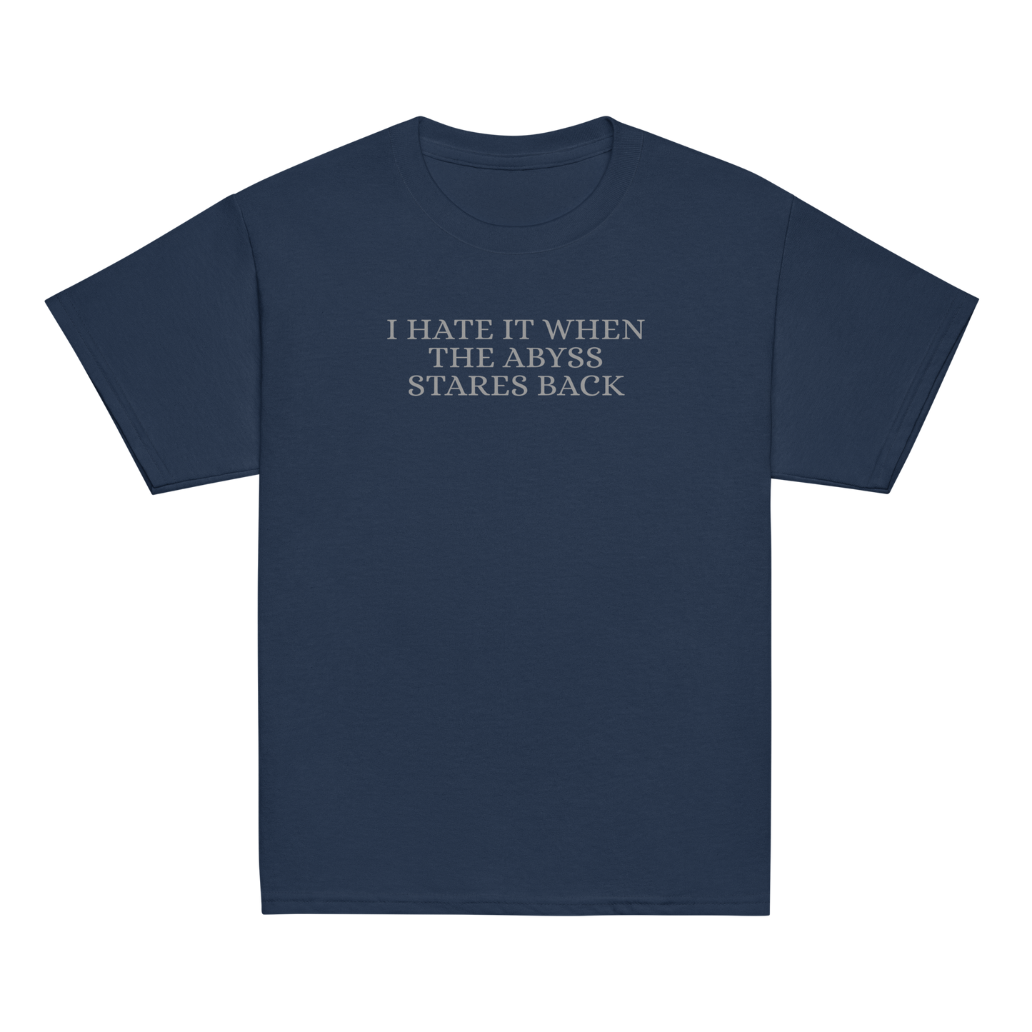 "I hate it when the abyss stares back" printed on a navy youth classic tee laying on a flat surface