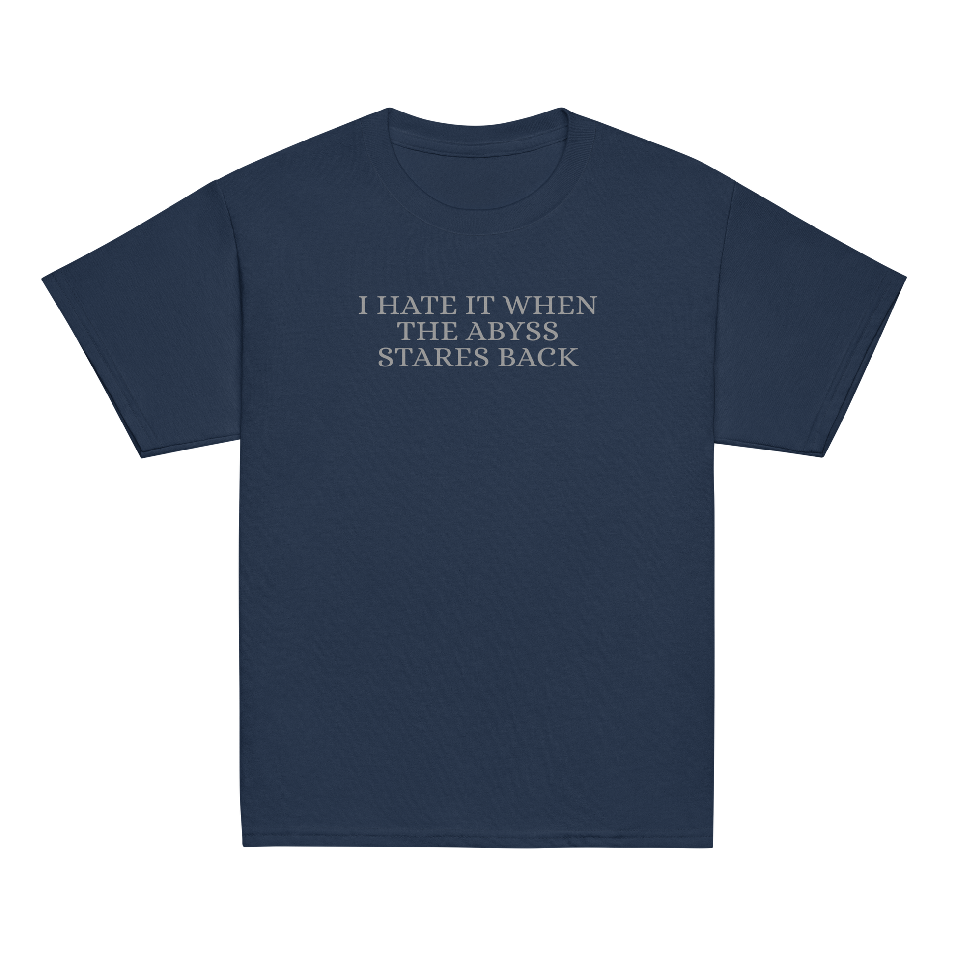 "I hate it when the abyss stares back" printed on a navy youth classic tee laying on a flat surface