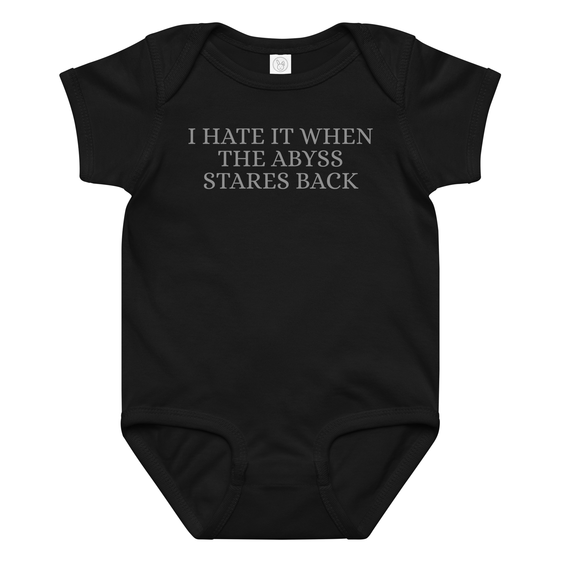 "I hate it when the abyss stares back" printed on a black baby jersey bodysuit laying on a flat surface amongst other clothes
