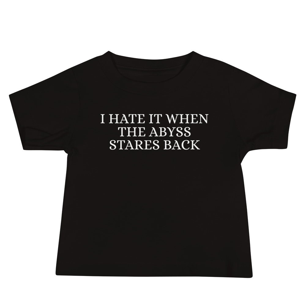 "I hate it when the abyss stares back" printed on a black baby jersey short sleeve tee laying on a flat surface