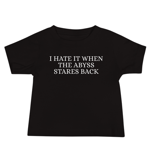 "I hate it when the abyss stares back" printed on a black baby jersey short sleeve tee laying on a flat surface