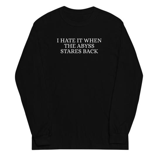 "I hate it when the abyss stares back" printed on a black men's long sleeve shirt laying on a flat surface