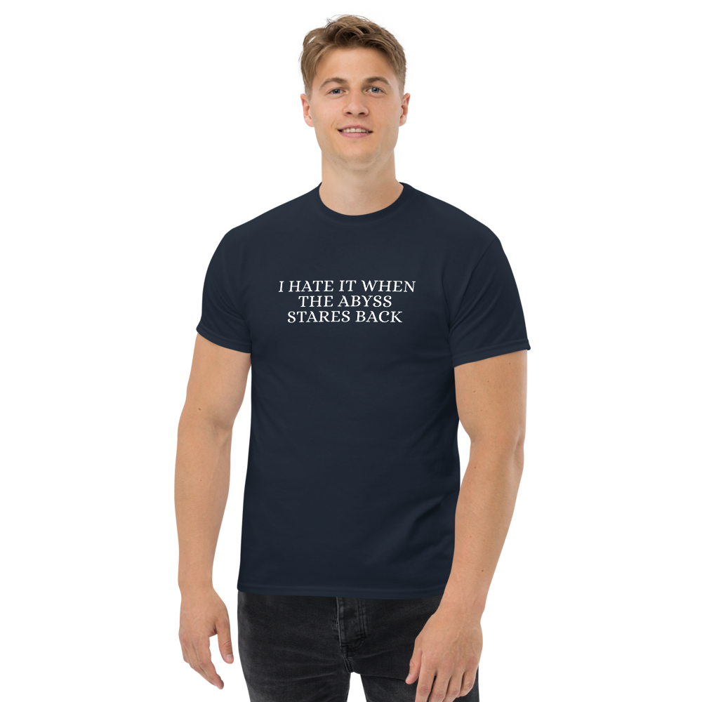 "I hate it when the abyss stares back" printed on a navy unisex classic tee worn by a male