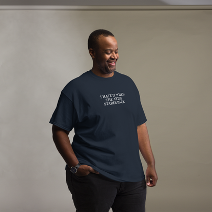 "I hate it when the abyss stares back" printed on a navy unisex classic tee worn by a male