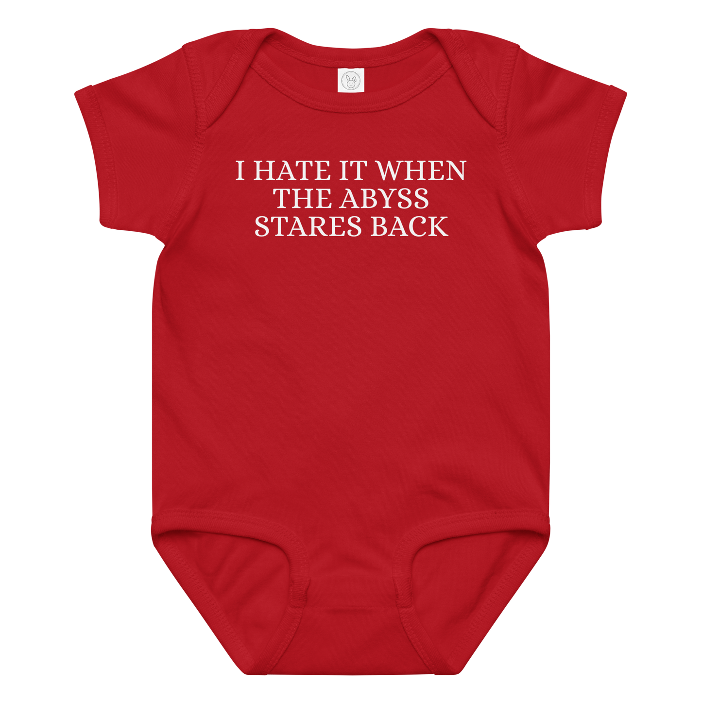"I hate it when the abyss stares back" printed on a red baby jersey bodysuit laying on a flat surface amongst other clothes