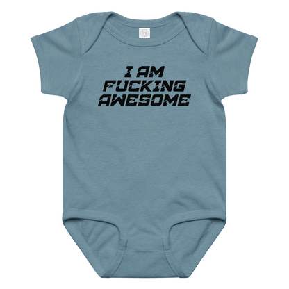 "I Am Fucking Awesome" printed on a vintage indigo baby jersey bodysuit laying on a flat surface amongst other clothes