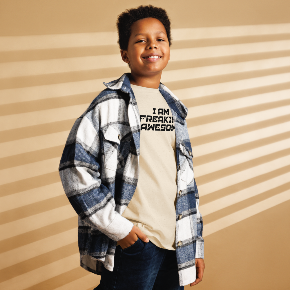 "I Am Freaking Awesome" printed on a natural youth classic tee worn by a male also wearing a jacket