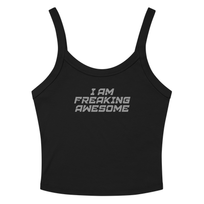 "I Am Freaking Awesome" printed on a solid black blend women's micro-rib tanktop laying on a flat surface amongst sunglasses and shorts