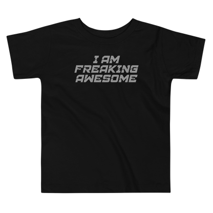 "I Am Freaking Awesome" printed on a black toddler short sleeve tee laying on a flat surface