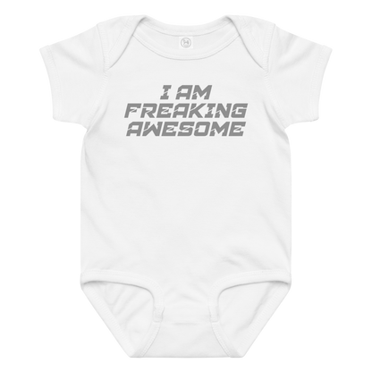 "I Am Freaking Awesome" printed on a white baby jersey bodysuit laying on a flat surface amongst other clothes