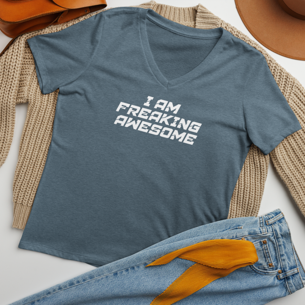 "I Am Freaking Awesome" printed on a heather slate women's relaxed v-neck t-shirt laying on a flat surface amongst other clothes