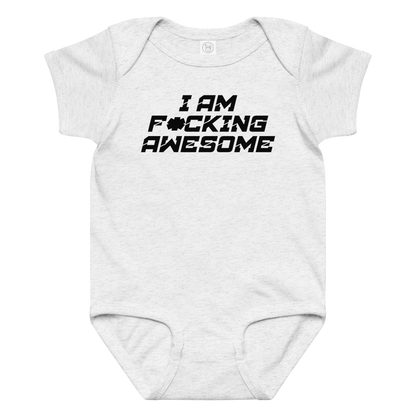 "I Am F*cking Awesome" printed on a ash baby jersey bodysuit laying on a flat surface amongst other clothes