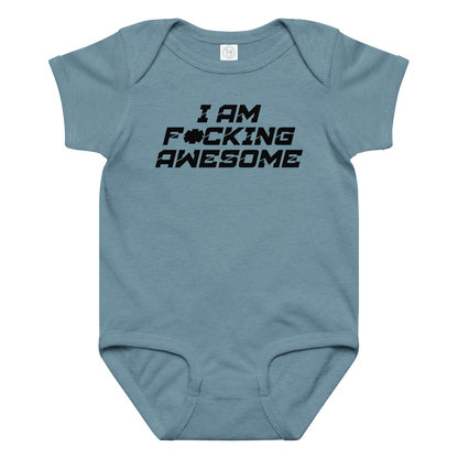 "I Am F*cking Awesome" printed on a vintage indigo baby jersey bodysuit laying on a flat surface amongst other clothes