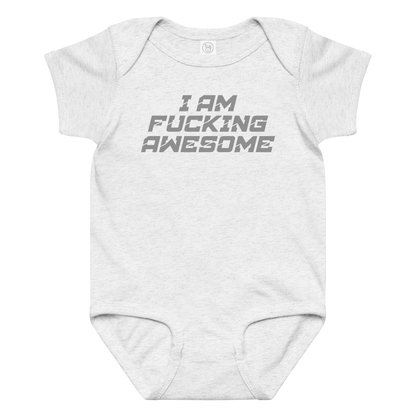 "I Am Fucking Awesome" printed on a ash baby jersey bodysuit laying on a flat surface amongst other clothes