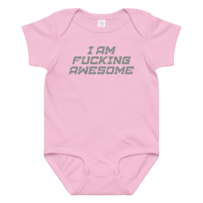 "I Am Fucking Awesome" printed on a pink baby jersey bodysuit laying on a flat surface amongst other clothes
