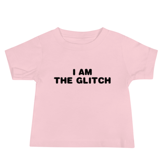 "I am the glitch" printed on a pink baby jersey short sleeve tee laying on a flat surface