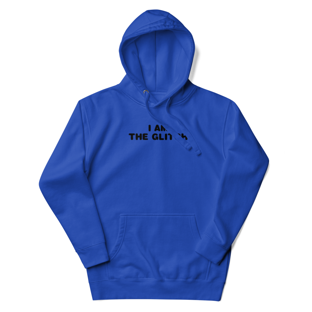 "I am the glitch" printed on a team royal unisex hoodie laying on a flat surface with the hood up