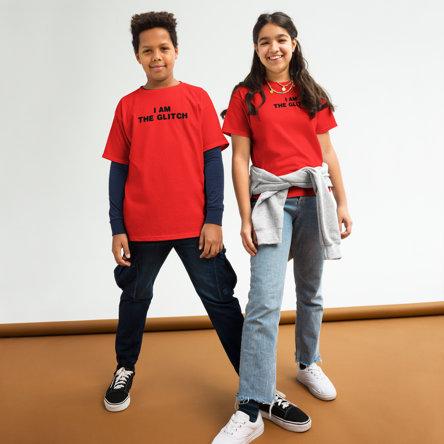 "I am the glitch" printed on a red youth classic tee worn by a female and male