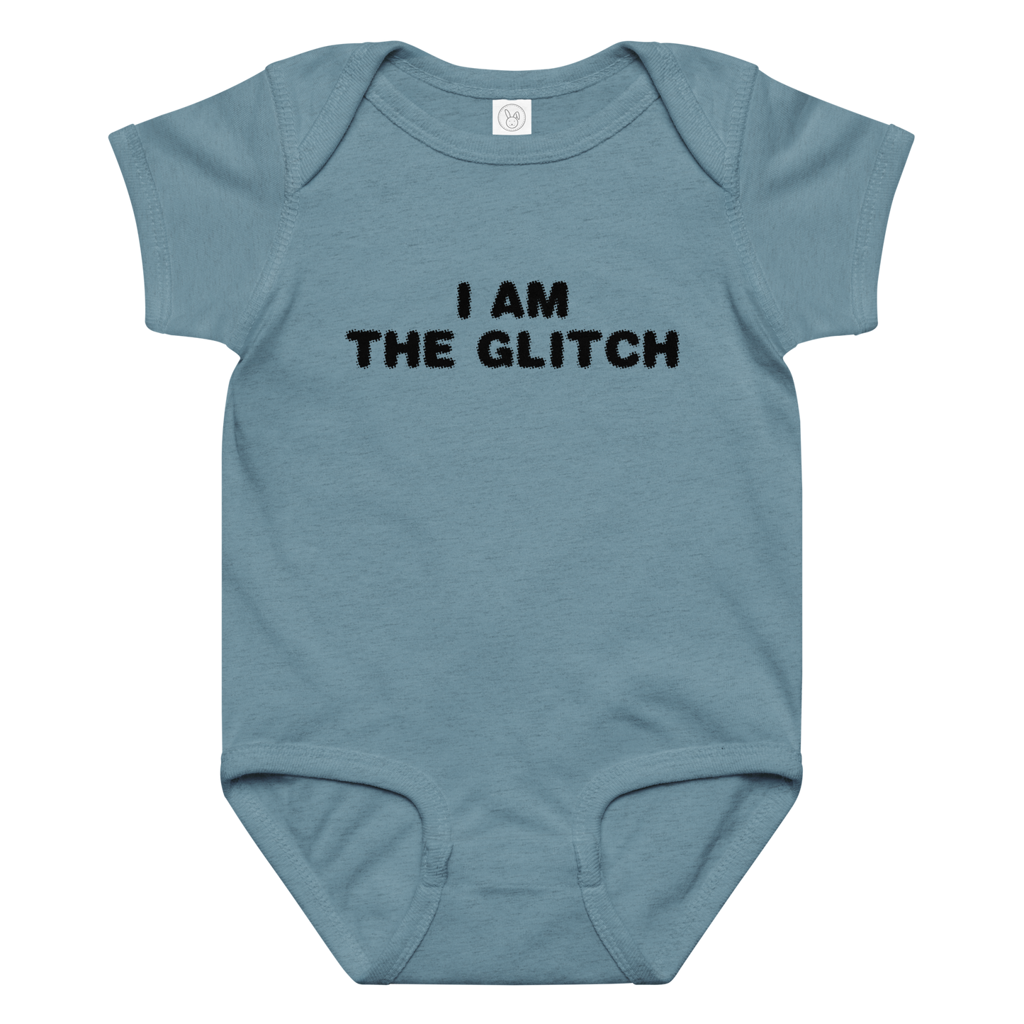 "I am the glitch" printed on a vintage indigo baby jersey bodysuit laying on a flat surface amongst other clothes